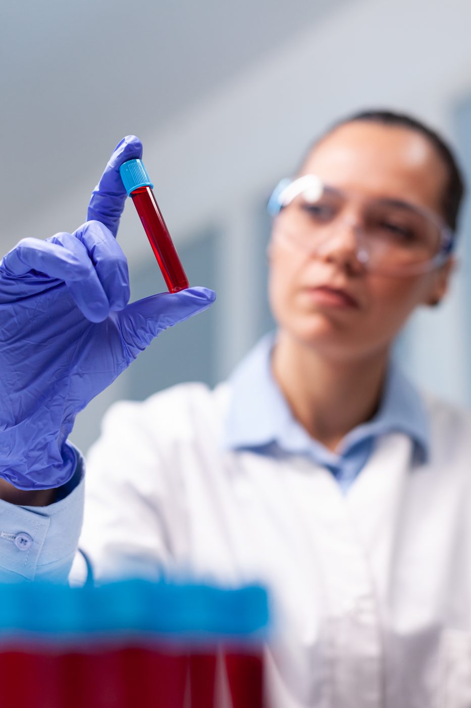 Profissional analisa tubo de amostra de sangue