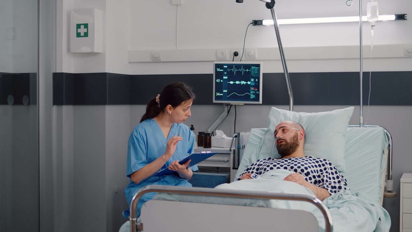 Profissional acompanha paciente em leito de terapia intensiva